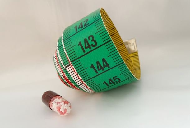 measuring tape and pill