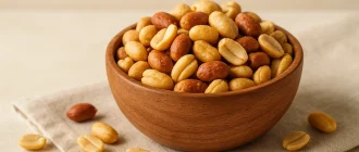 Bowl of roasted peanuts on linen cloth – healthy snack for pregnancy with plant-based protein and folate