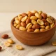 Bowl of roasted peanuts on linen cloth – healthy snack for pregnancy with plant-based protein and folate