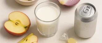 Common dietary triggers of bloating including garlic, onion, apple slices, milk, soda, and sugar-free candies on a clean background with text Dietary Triggers of Bloating