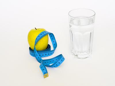 Apple, ribbon and a glass of water