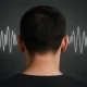 Visual concept of tinnitus — noise in the head shown as sound waves affecting a man, symbolizing the experience of constant ringing or vibration in the ears.
