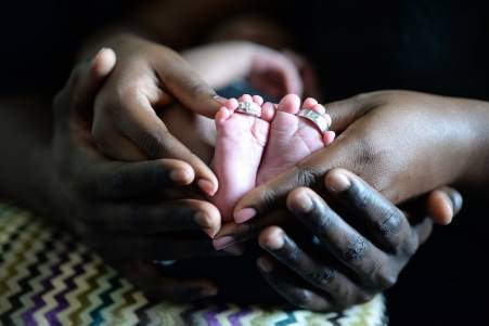 Baby feet and hands of parents