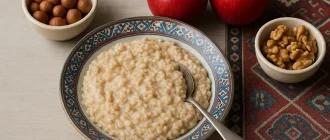 A wholesome bowl of oatmeal with red apples and nuts — nutrient-rich foods that naturally support liver health.