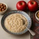 A wholesome bowl of oatmeal with red apples and nuts — nutrient-rich foods that naturally support liver health.